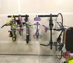 Kids and adult bikes hanging on Blackstone racks along a garage wall