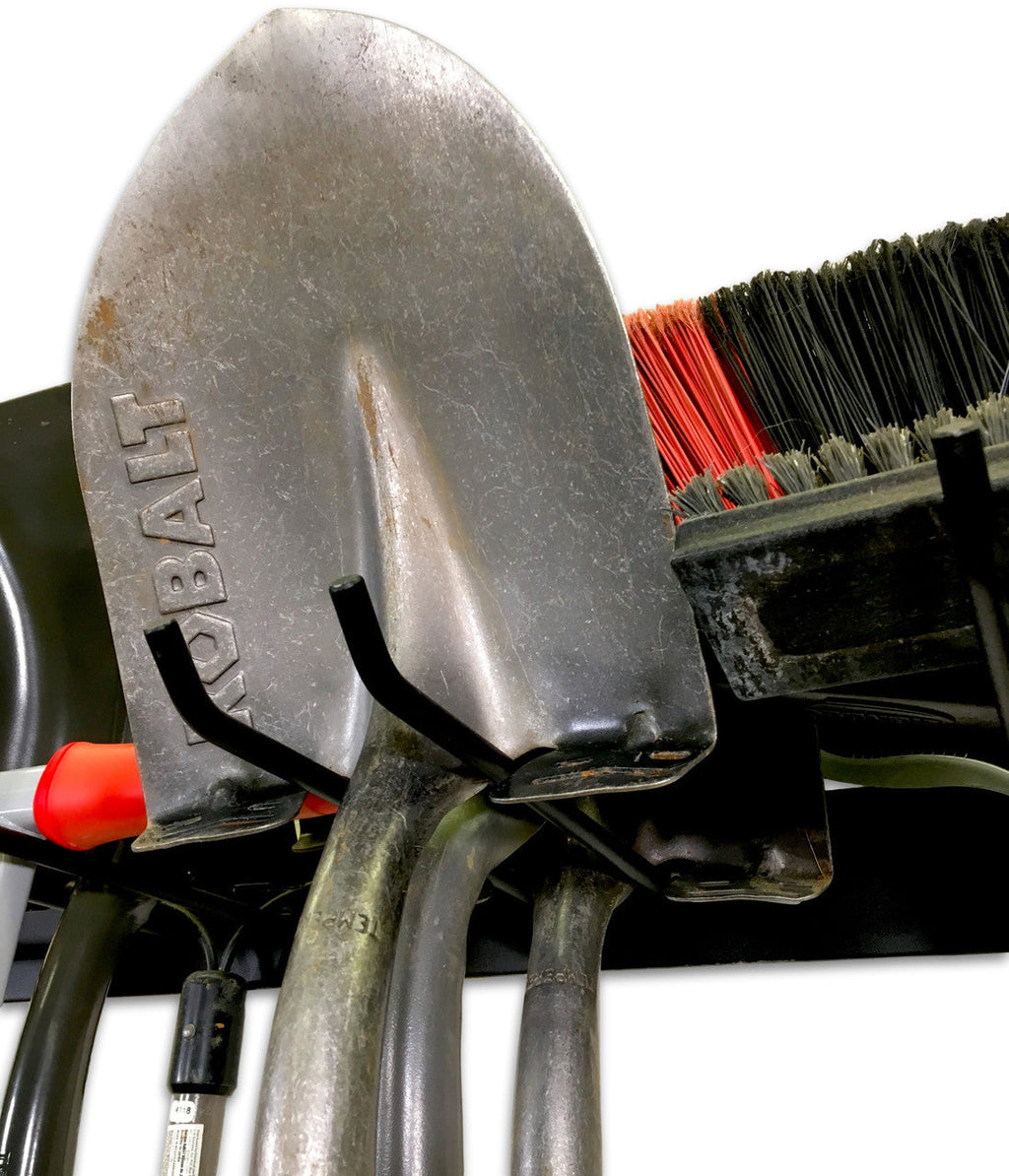 Close-up of a shovel hanging on the black tool organizer hooks