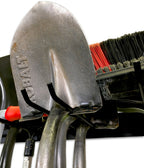 Close-up of a shovel hanging on the black tool organizer hooks