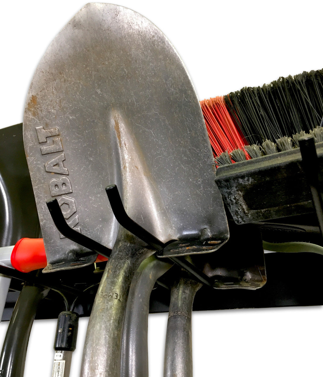Close-up of a shovel hanging on the black tool organizer hooks