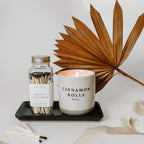 Matte black stoneware tray holding a candle and a jar of safety matches