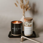 Matte black stoneware tray holding a candle and a jar of matches