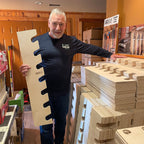 Man holding a garden tool organizer rack in a workshop