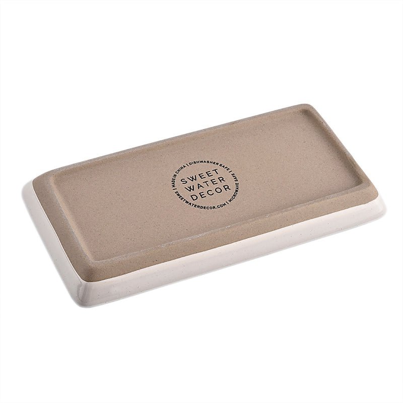 Underside of the cream stoneware tray showing the Sweet Water Decor stamp