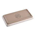 Underside of the cream stoneware tray showing the Sweet Water Decor stamp
