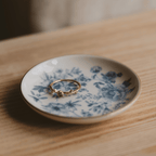 Blue Delft jewelry dish holding a ring on a wooden table