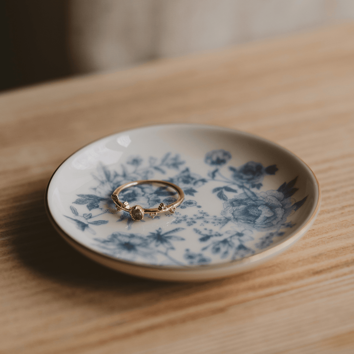 Blue Delft jewelry dish holding a ring on a wooden table