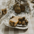 Green Delft floral melamine tray holding cheese, olives and pears on a table