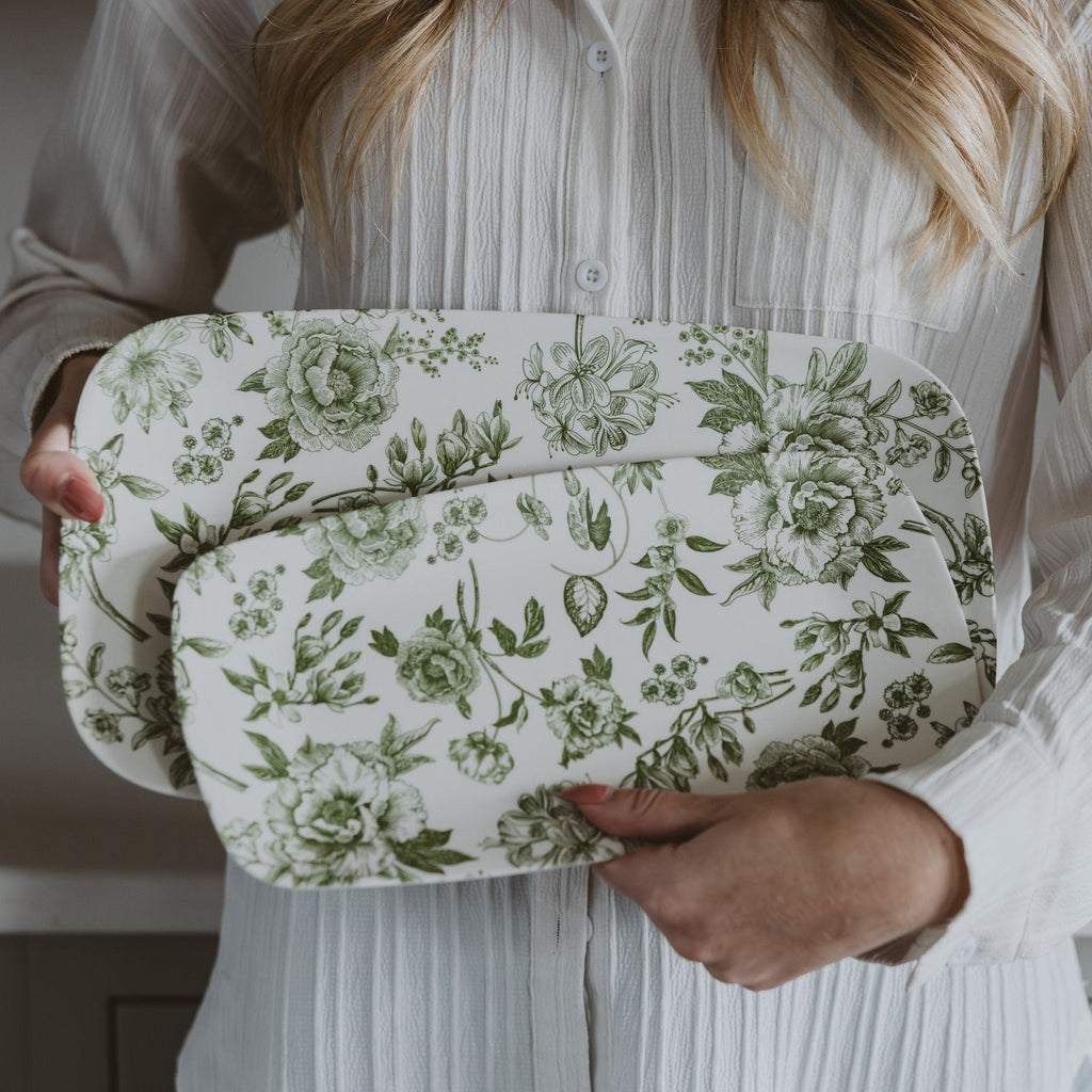 Woman holding the two stacked green Delft floral melamine trays