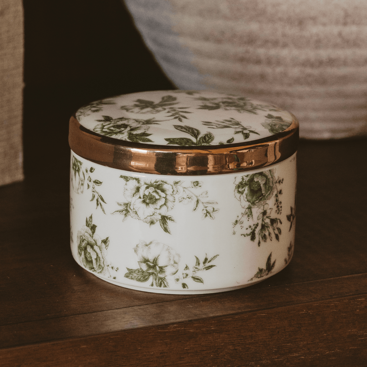 Green Delft round ceramic trinket box with gold-rimmed lid on a wooden shelf