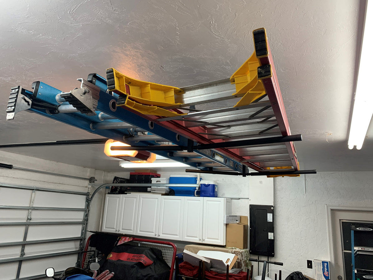Kayaks and paddleboards stored on the ceiling rack in a garage