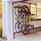 Four bikes hanging on the wall rack in a garage beside the open door