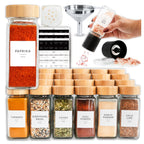 Paprika jar with bamboo lid beside the funnel, grinder, sifter lid and label sheets
