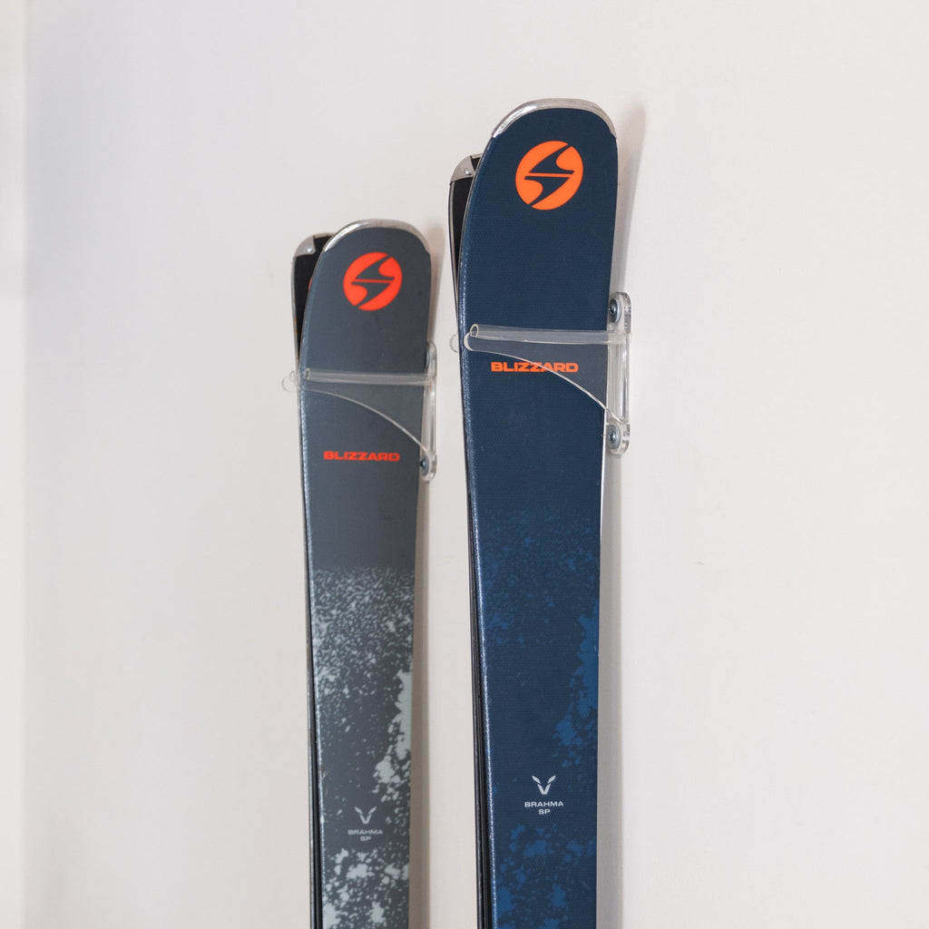 Close-up of two pairs of skis held by clear racks