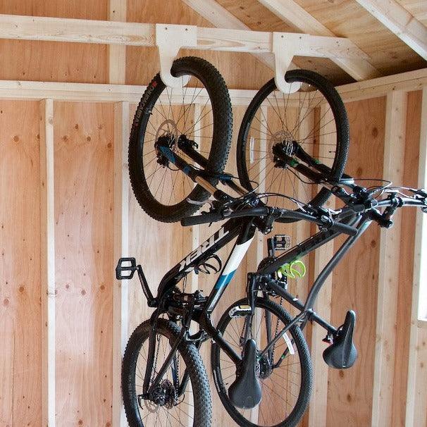 Two mountain bikes hanging on wood bike hooks