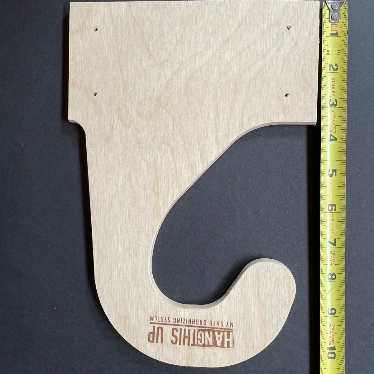 Wood bike hook with a tape measure showing its size