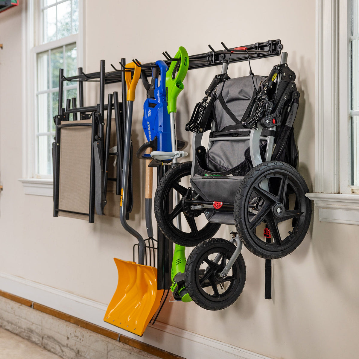 Folding chairs, a snow shovel and a wagon hung on the wall organizer