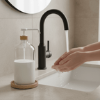 Washing hands at a sink next to the clear 1 L pump bottle
