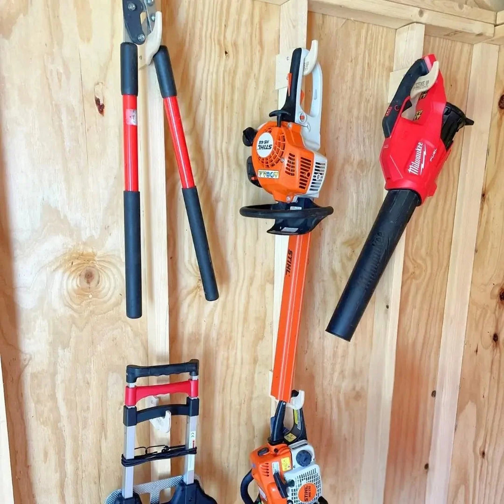 Wall hooks holding loppers, a hedge trimmer and a leaf blower