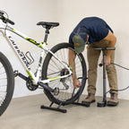 Man pumping a tire while the bike stands in the CycleStand