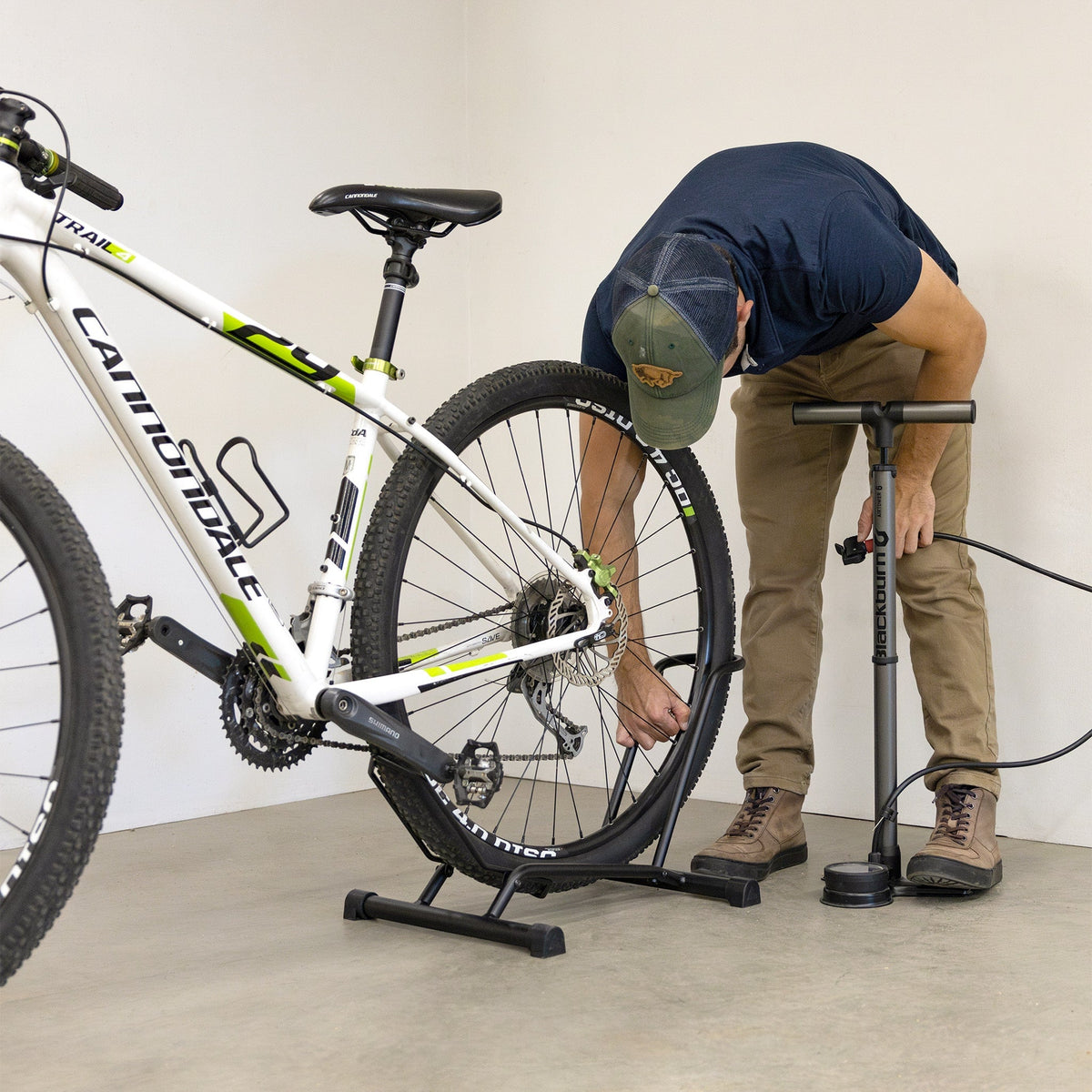 Man pumping a tire while the bike stands in the CycleStand