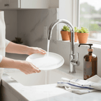 Rinsing a plate at the sink next to the amber dish soap bottle