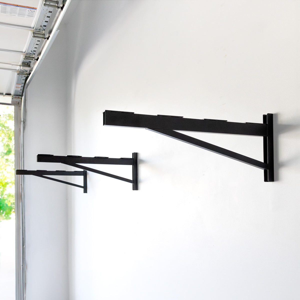 Three empty 2 x 8 ft DIY shelf brackets mounted on a wall