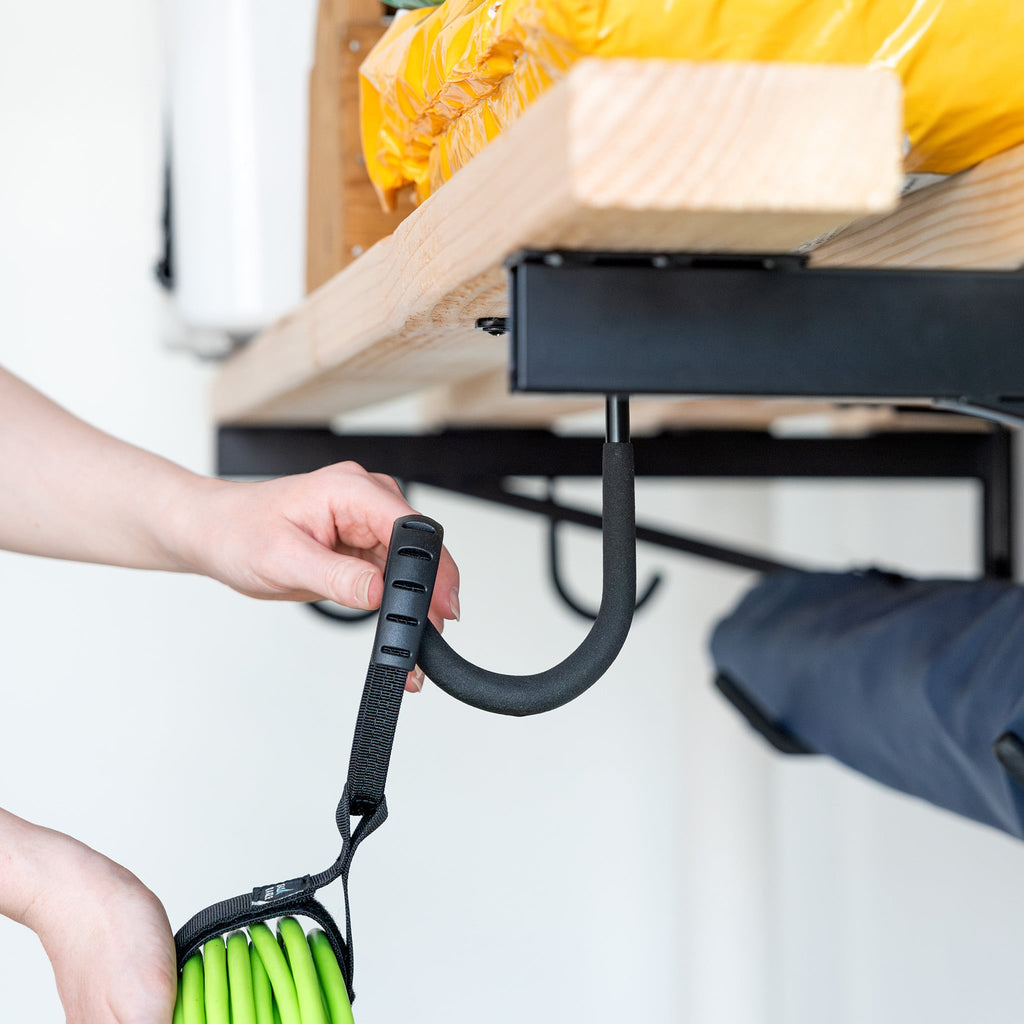 Hand hanging a leaf blower strap on the bracket hook