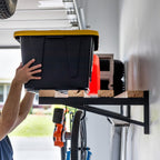 Person lifting a tote onto the long wood shelf