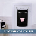 Black hanging laundry hamper installed behind a bathroom door