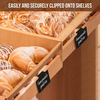Reusable black clip-on chalkboard labels attached to wooden bakery display shelves