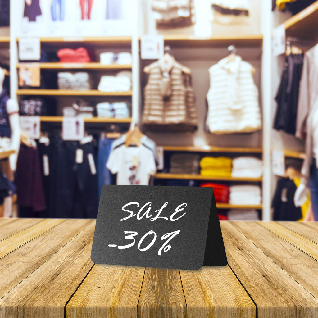 Black mini chalkboard tent sign displaying a sale message on a table