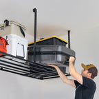 Person lifting a storage bin onto an overhead garage ceiling rack