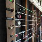 Wood fishing rod rack holding several rods with reels