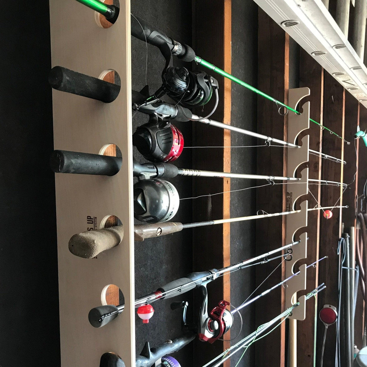 Wood fishing rod rack holding several rods with reels