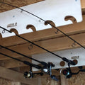 Fishing rods stored on wood racks under a shed ceiling