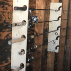 Wood fishing rod rack holding rods vertically on a shed wall