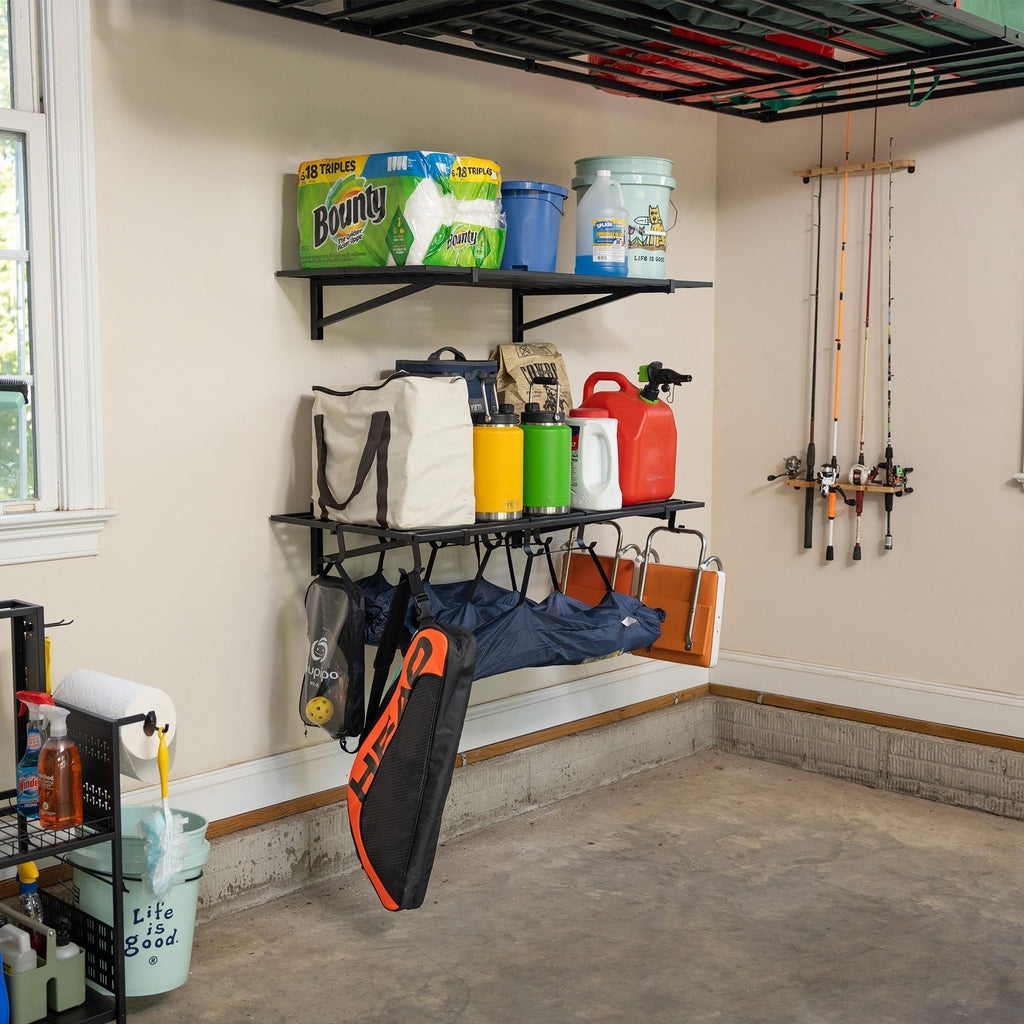 Black garage wall shelves holding paper towels, bins and sports gear with tools hung underneath