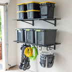Two black 2 x 4 ft wall shelves holding storage bins, with a folding cart and buckets hung below