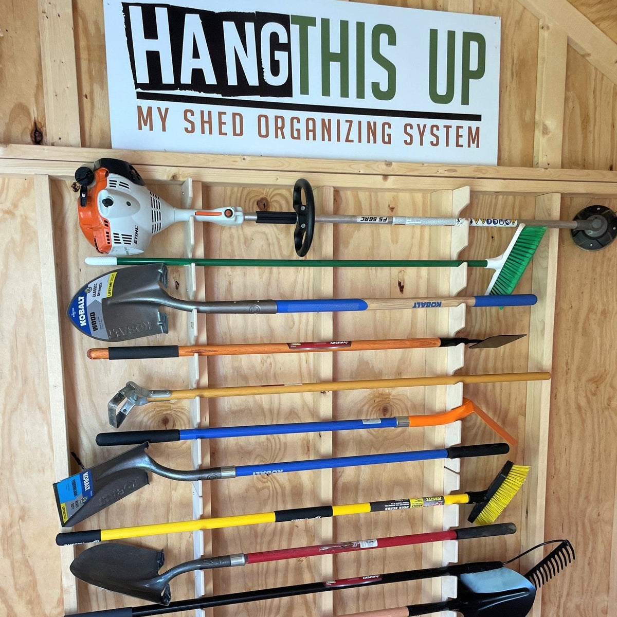 Garden tool organizer rack holding shovels, rakes and a trimmer in a shed