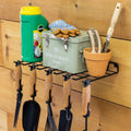 Garden tool shelf holding a watering can, gloves and pots with hand tools hung below
