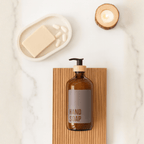 Amber hand soap bottle on a wooden board on marble