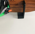 Close-up of a snowboard resting on the black wall rack