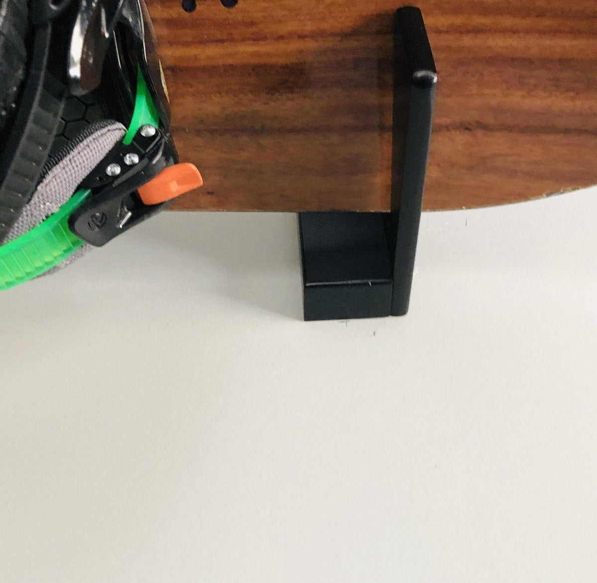Close-up of a snowboard resting on the black wall rack