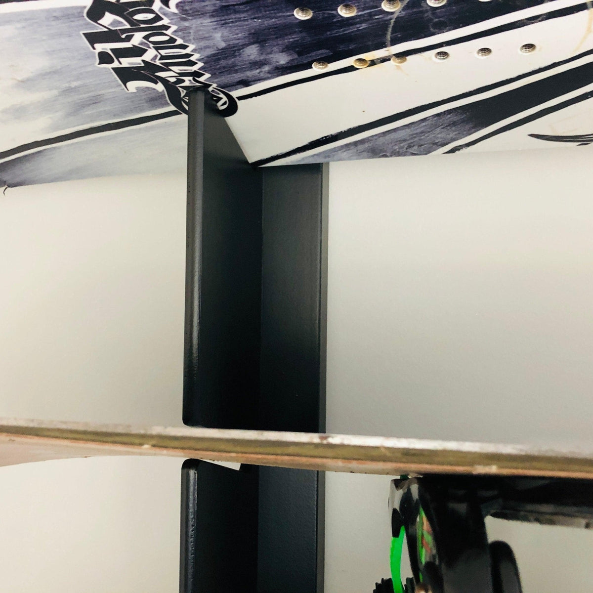 Close-up of a snowboard rack rail holding a board