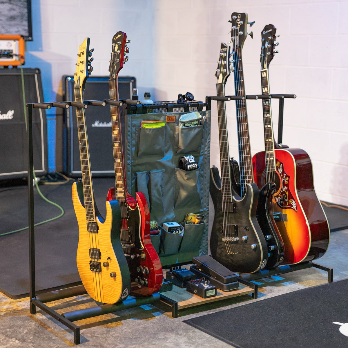 Gray guitar rack holding electric and acoustic guitars in a music room
