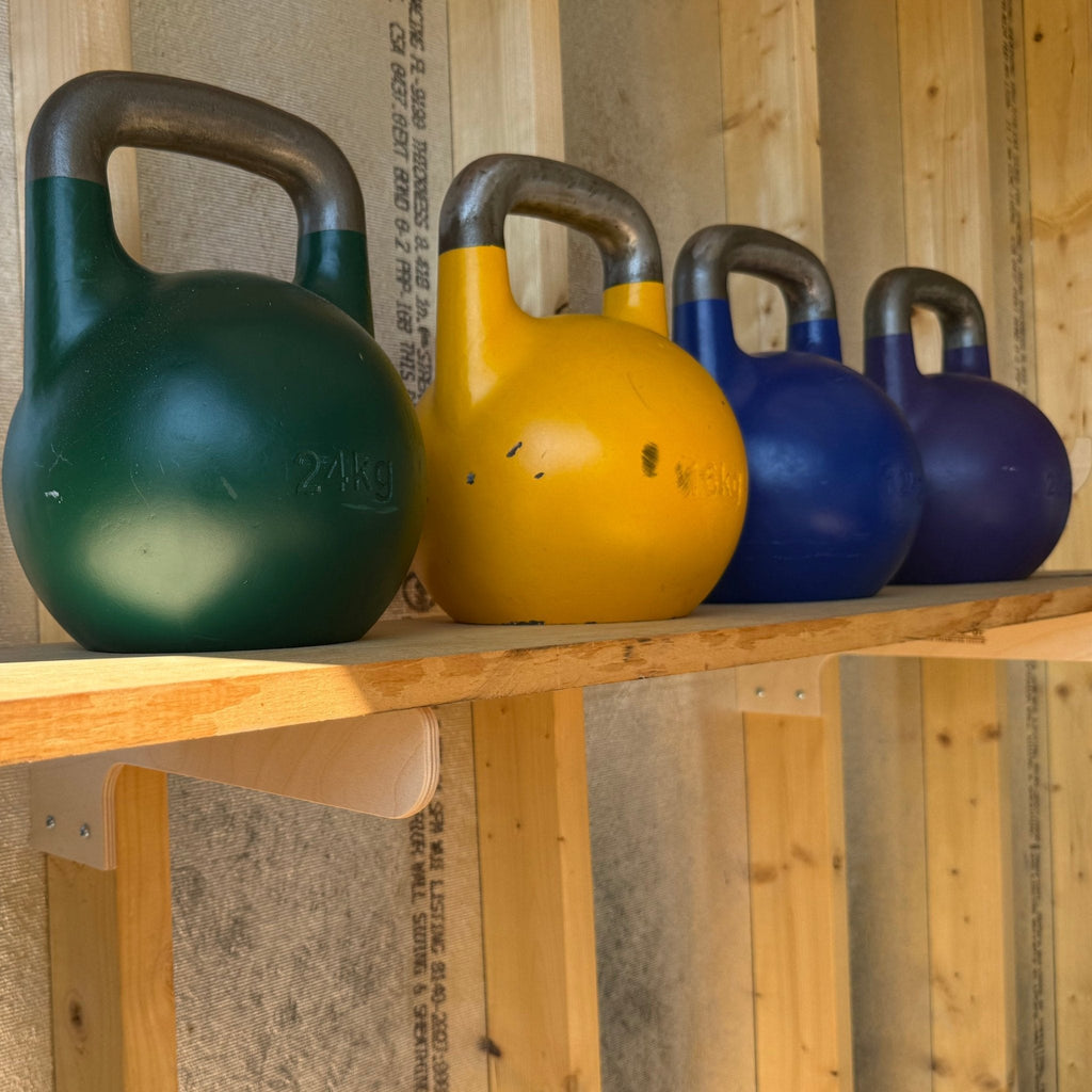 Kettlebells resting on a shelf held by shed shelf brackets