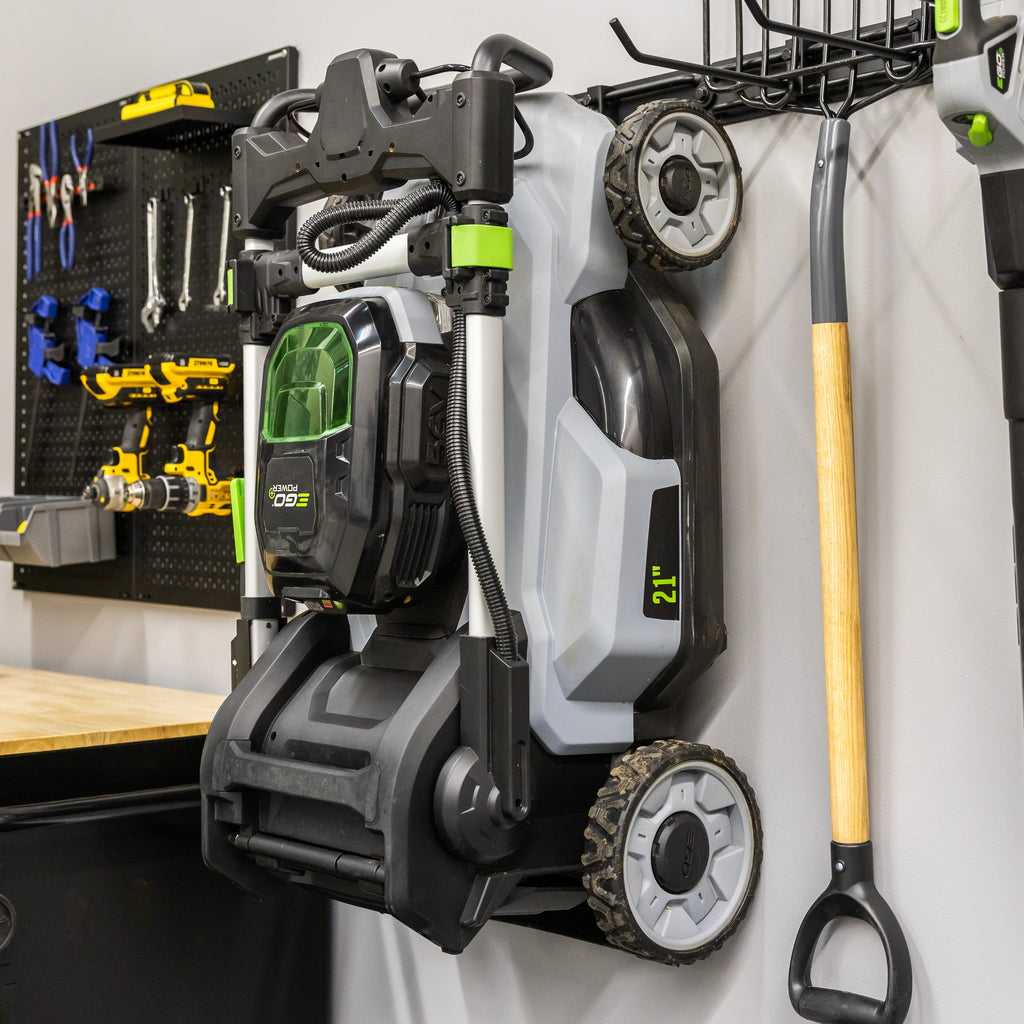 Lawn mower and yard tools hung on the wall organizer next to a pegboard