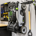 Lawn mower and yard tools hung on the wall organizer next to a pegboard