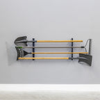 Shed tool organizer on a gray wall holding shovels and rakes horizontally